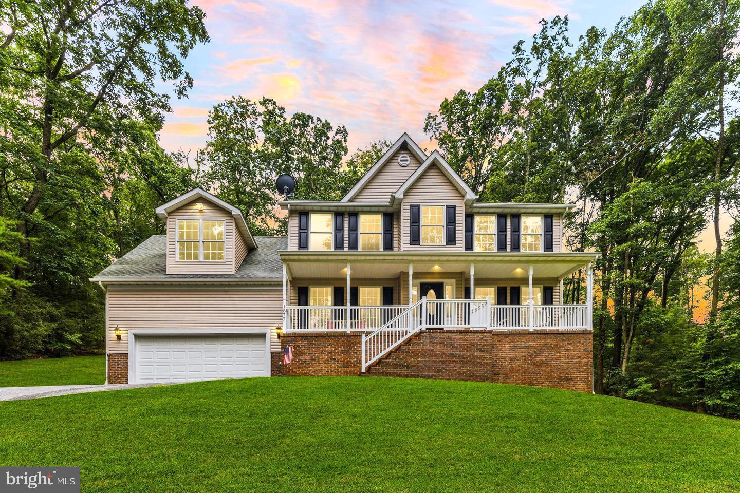 a front view of a house with a yard and trees