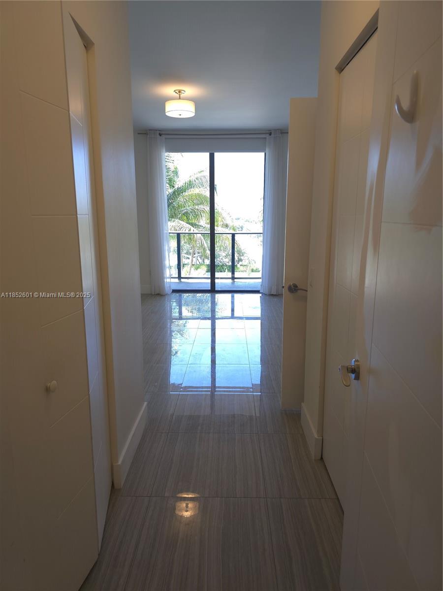 2960 Northeast 207th Street, Unit 713 Aventura, FL 33180 - Photo 16 of 33 a view of hallway with a large window and wooden floor