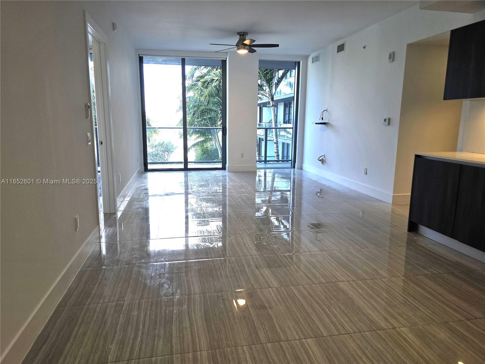 2960 Northeast 207th Street, Unit 713 Aventura, FL 33180 - Photo 2 of 33 a view of empty room with wooden floor and fan