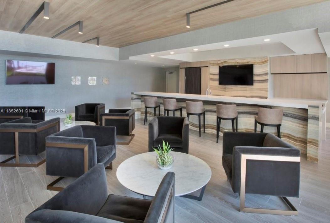 2960 Northeast 207th Street, Unit 713 Aventura, FL 33180 - Photo 33 of 33 a living room with furniture kitchen view and a flat screen tv