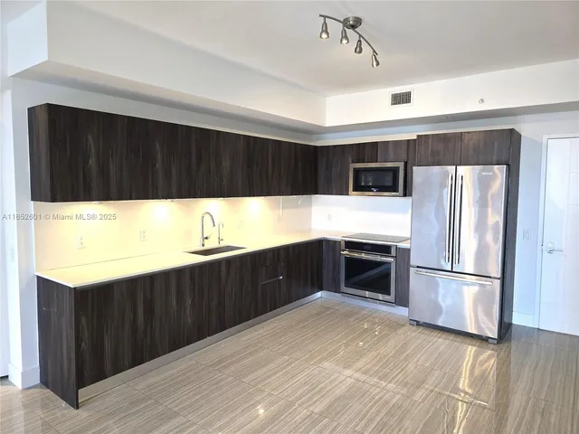 a kitchen with stainless steel appliances a stove a refrigerator and a sink