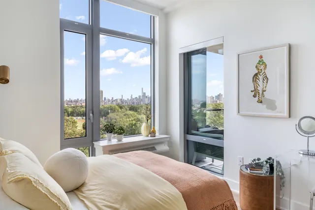 a bedroom with a bed and a large window with chair