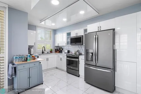 a kitchen with stainless steel appliances granite countertop a refrigerator and a sink
