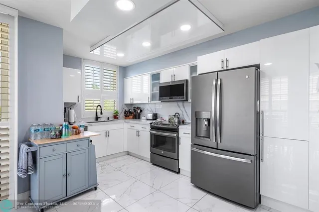 a kitchen with stainless steel appliances granite countertop a refrigerator and a sink