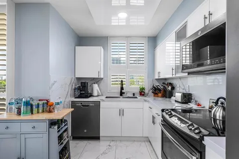 a bathroom with a granite countertop sink a toilet and a mirror