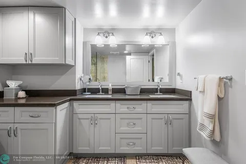 a bedroom with a bed and dresser with wooden floor