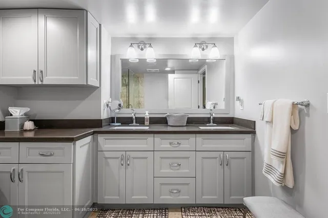 a bedroom with a bed and dresser with wooden floor