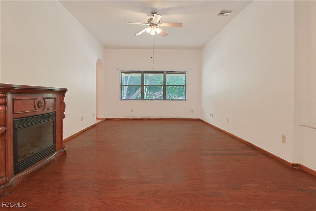 6620 Golden Road North Fort Myers, FL 33917 - Photo 11 of 26 an empty room with a fireplace and windows