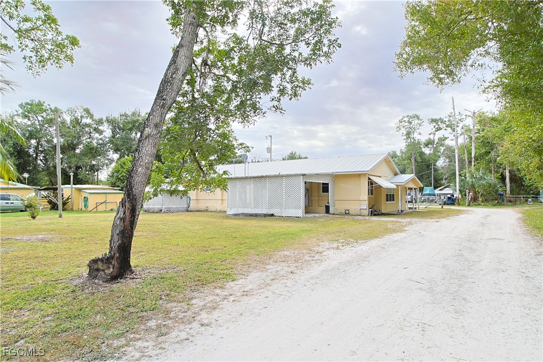 6620 Golden Road North Fort Myers, FL 33917 - Photo 3 of 26 a front view of a house with a yard and trees