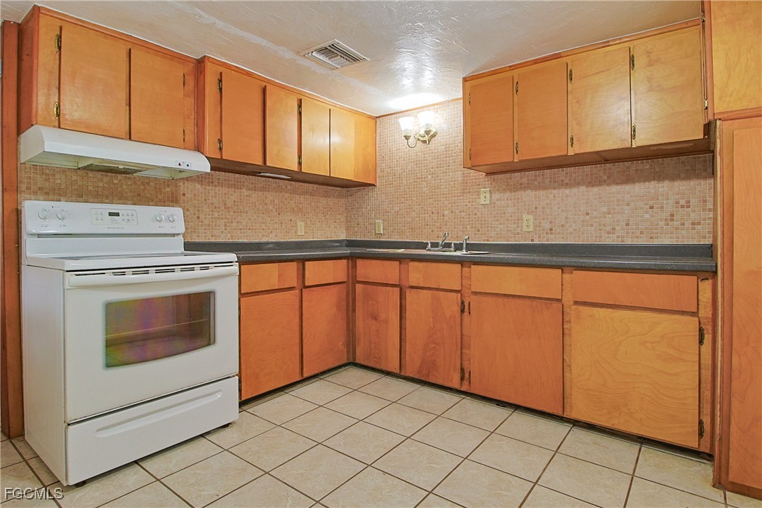 6620 Golden Road North Fort Myers, FL 33917 - Photo 7 of 26 a kitchen with granite countertop white cabinets stainless steel appliances and sink