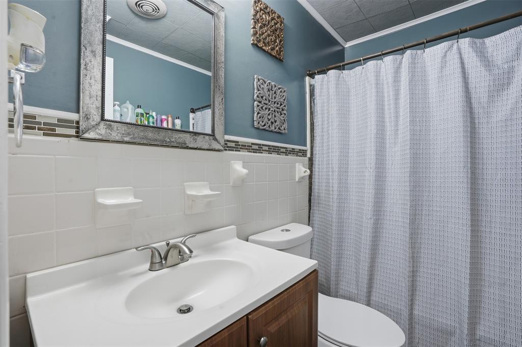 145 Bob White Road Denison, TX 75020 - Photo 11 of 24 a bathroom with a sink a toilet and a mirror