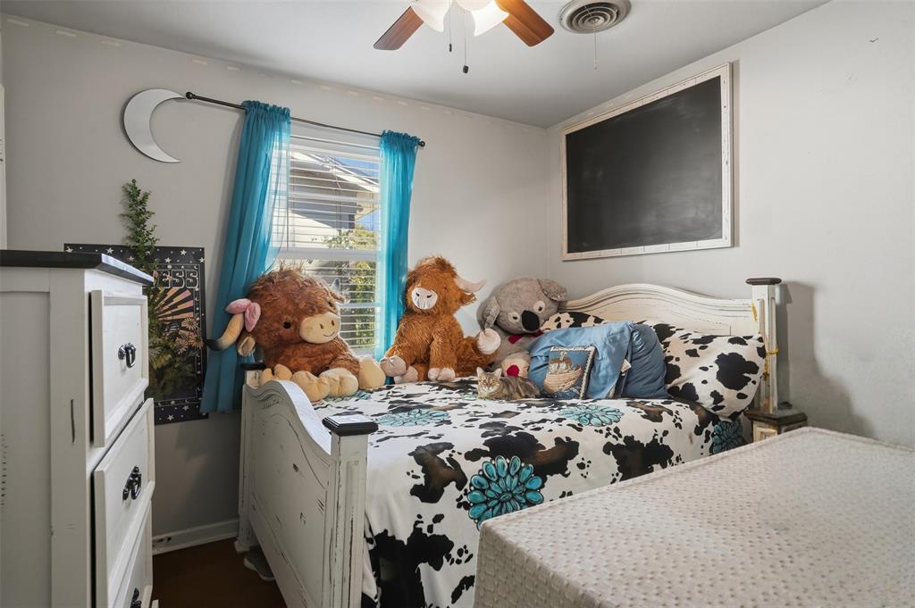 145 Bob White Road Denison, TX 75020 - Photo 9 of 24 a bed room with bed and a flat tv screen