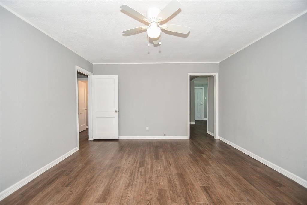 7334 Mountbatten Road Houston, TX 77033 - Photo 6 of 28 A spacious living area offers a versatile layout with convenient access to the hallway and adjoining rooms.