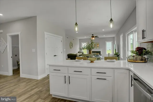 a kitchen with white cabinets and sink