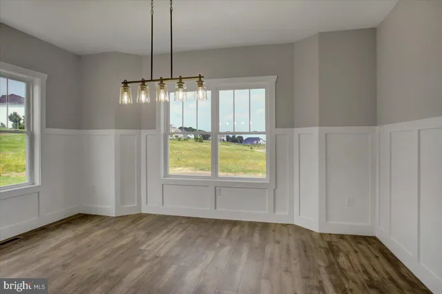 an empty room with window and wooden floor