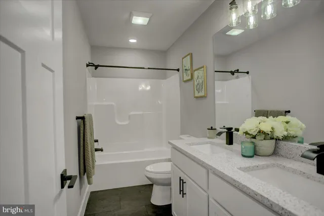 a bathroom with a granite countertop sink a toilet and shower