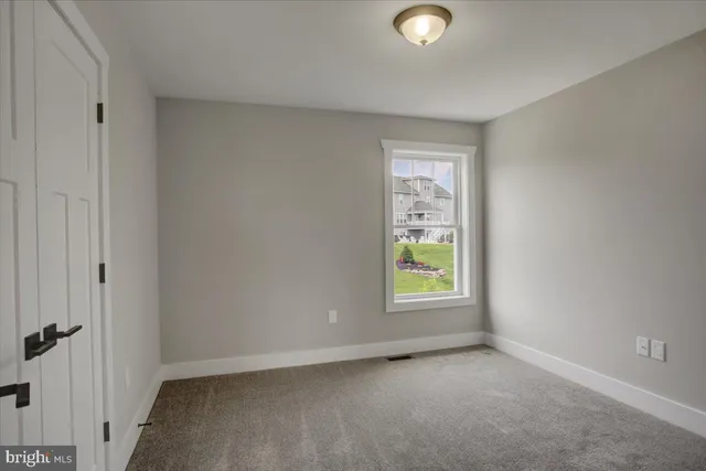 an empty room with window and mirror