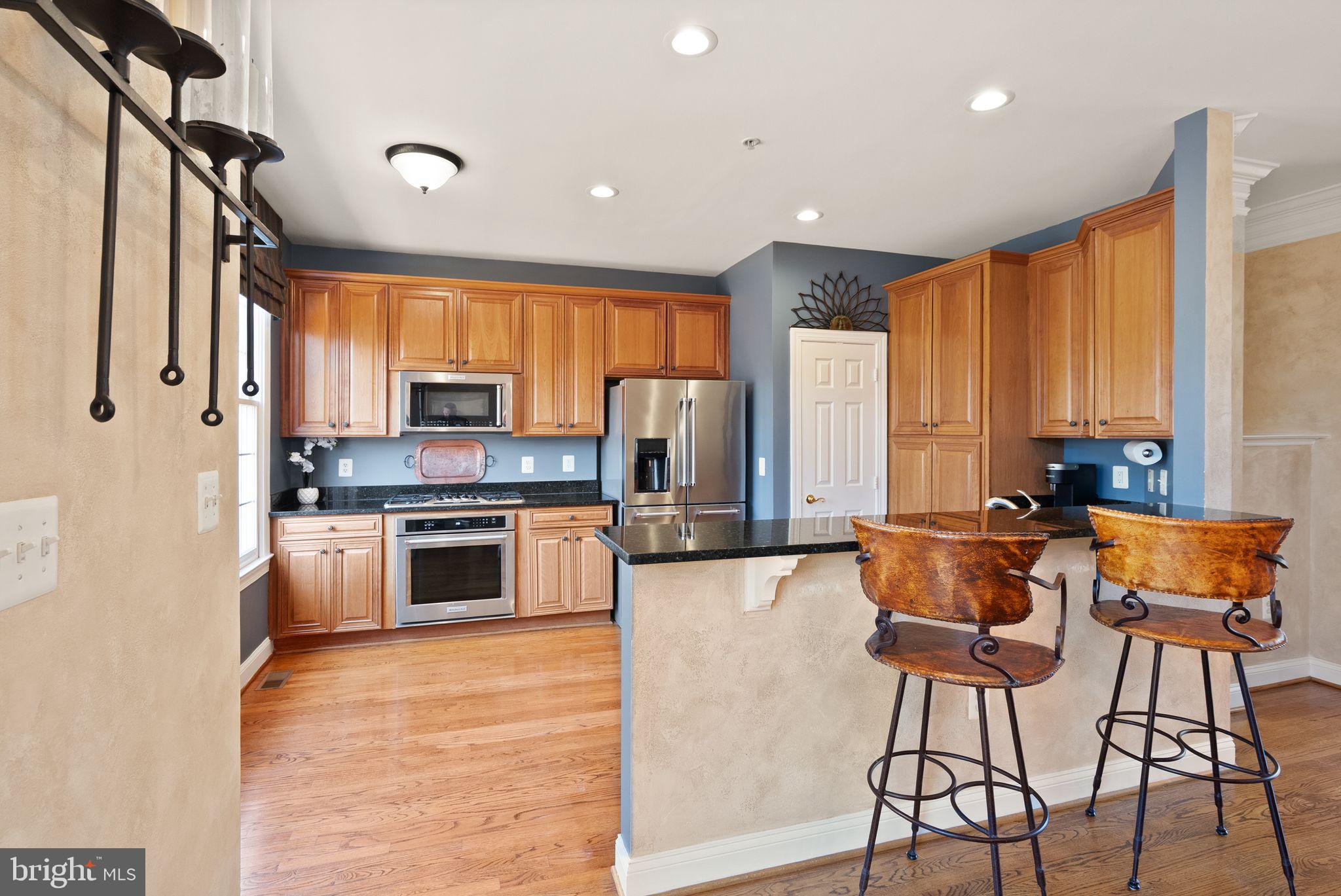 4132 Timber Log Way Fairfax, VA 22030 - Photo 2 of 69 a kitchen with stainless steel appliances kitchen island granite countertop a refrigerator and a stove top oven