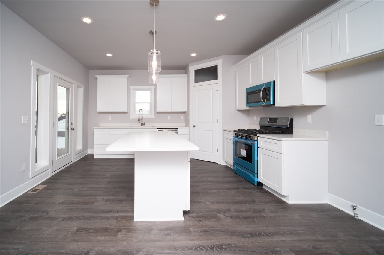 2435 Court Ridge Road Belvidere, IL 61008 - Photo 3 of 20 a large kitchen with stainless steel appliances kitchen island a sink dishwasher a stove and a refrigerator with wooden floor