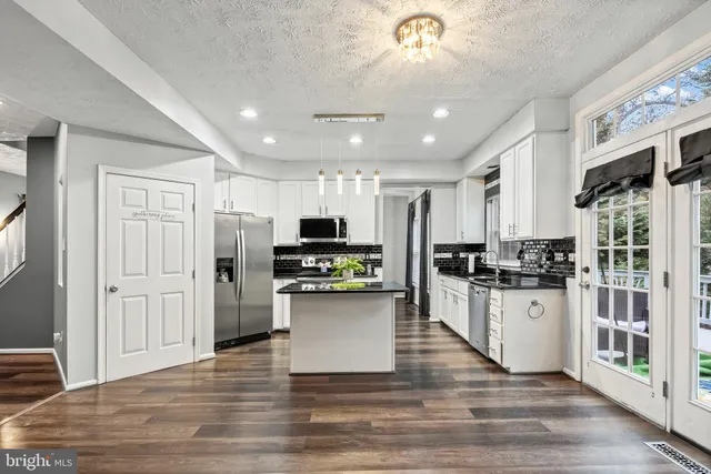 a kitchen with stainless steel appliances a refrigerator and a stove top oven