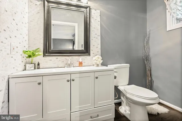 a bathroom with a toilet a sink a vanity and mirror