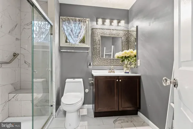 a bathroom with a toilet a sink and mirror