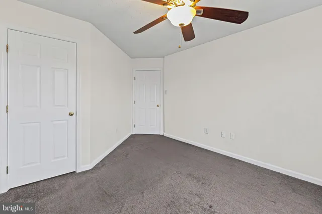 an empty room with a chandelier fan