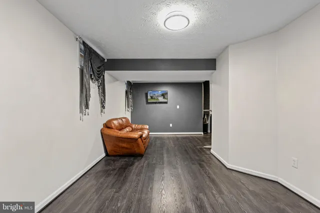 an empty room with wooden floor and ceiling fan