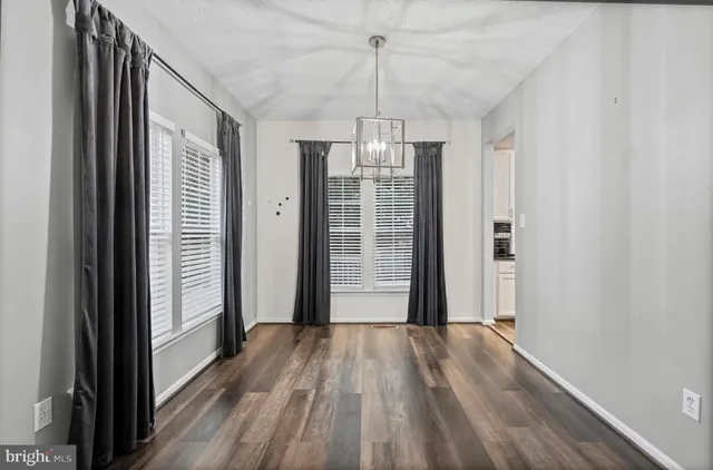 a view of a hallway with wooden floor and stairs