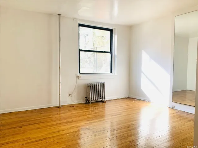 a view of room with wooden floor and windows