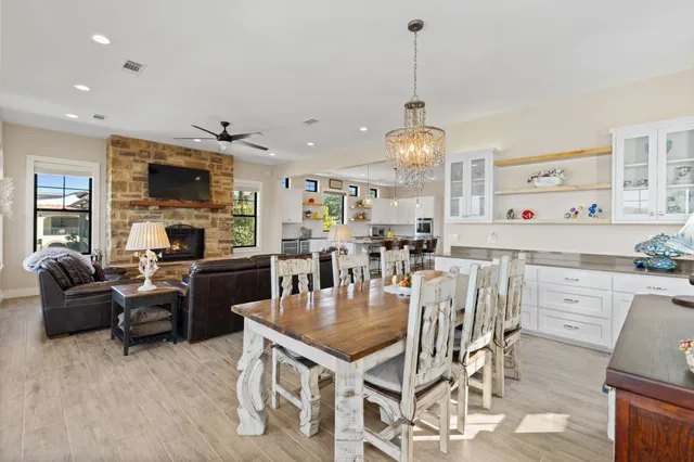 a living room with furniture a dining table and a chandelier