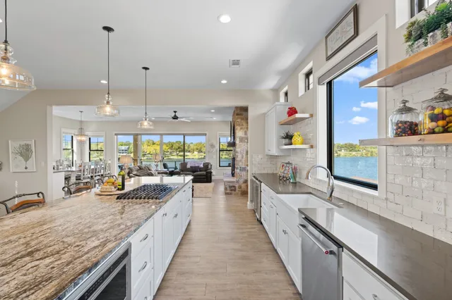 a large kitchen with kitchen island granite countertop lots of counter space and glass windows