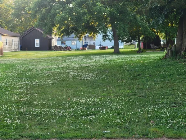 a large house with a big yard and large trees