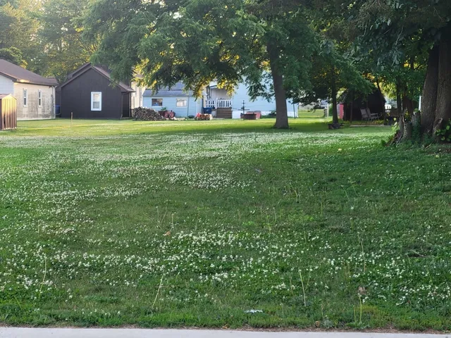 a front view of a house with a yard and trees