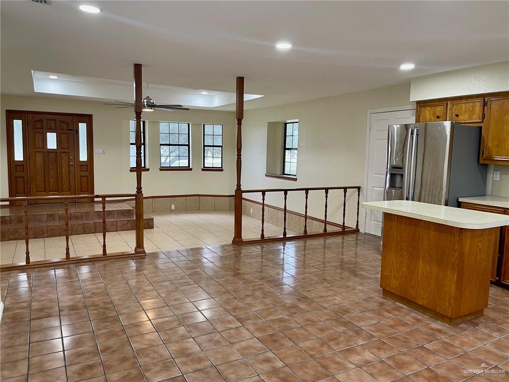 5307 Fm 493 Road Donna, TX 78537 - Photo 12 of 27 Kitchen with ceiling fan, light tile floors, a tray ceiling, stainless steel fridge with ice dispenser, and a center island