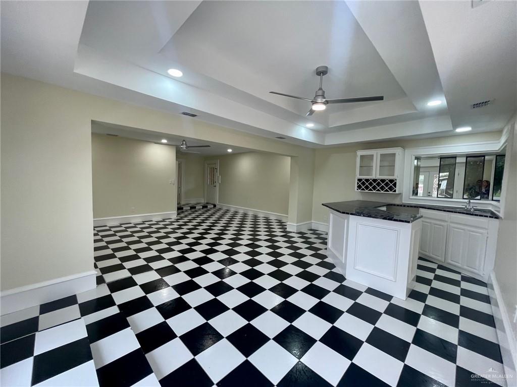 5307 Fm 493 Road Donna, TX 78537 - Photo 17 of 27 Kitchen featuring white cabinets, dark tile floors, and a raised ceiling