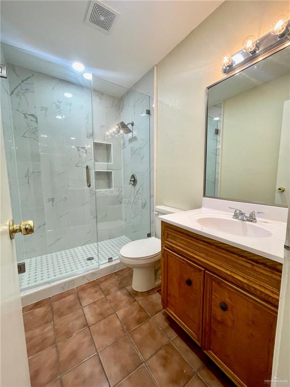 5307 Fm 493 Road Donna, TX 78537 - Photo 20 of 27 Bathroom featuring toilet, an enclosed shower, tile flooring, and oversized vanity