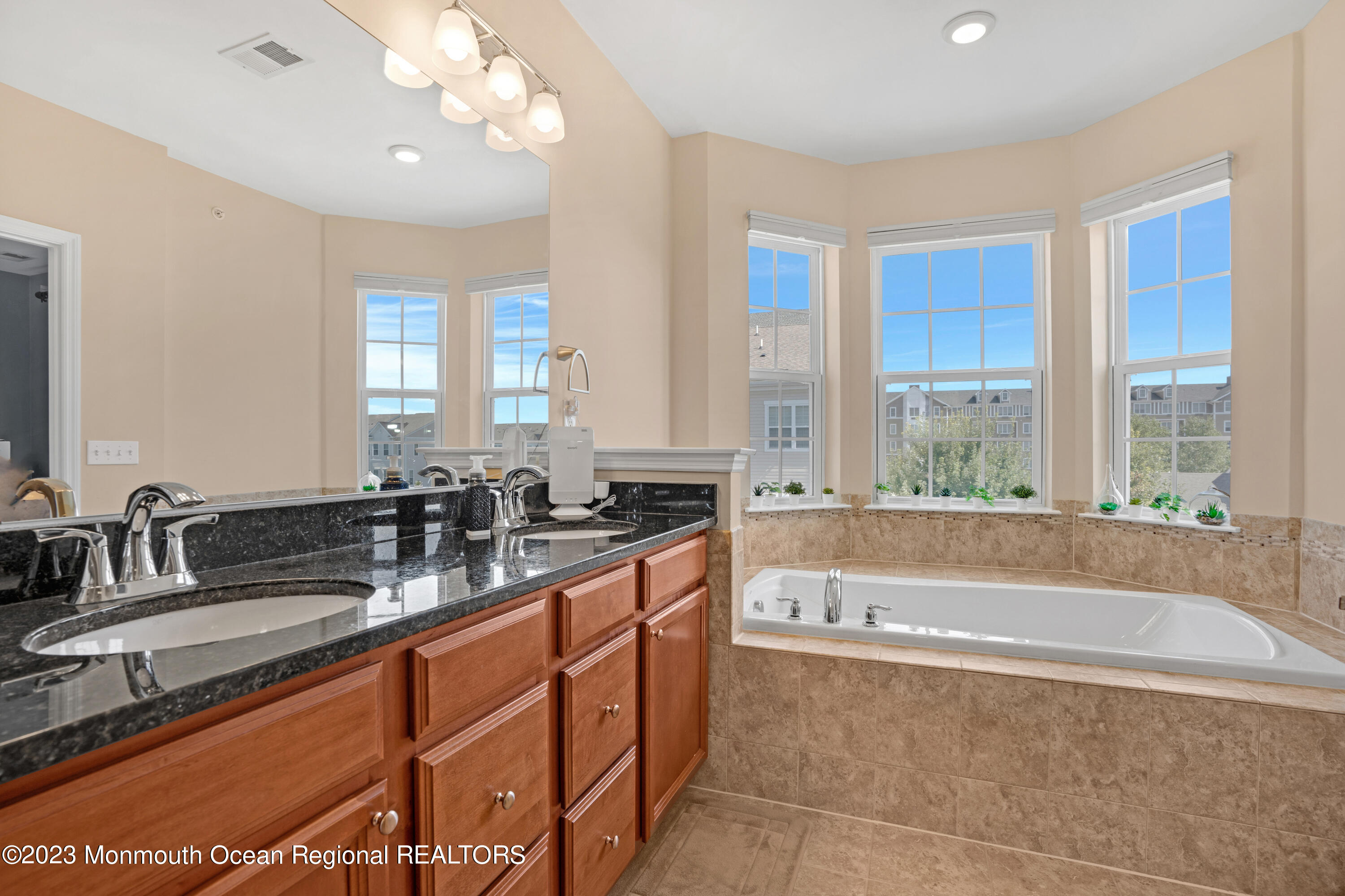 7 Iris Lane, Unit 504 Garfield, NJ 07026 - Photo 21 of 31 a bathroom with a granite countertop sink a large mirror and a bathtub next to a window