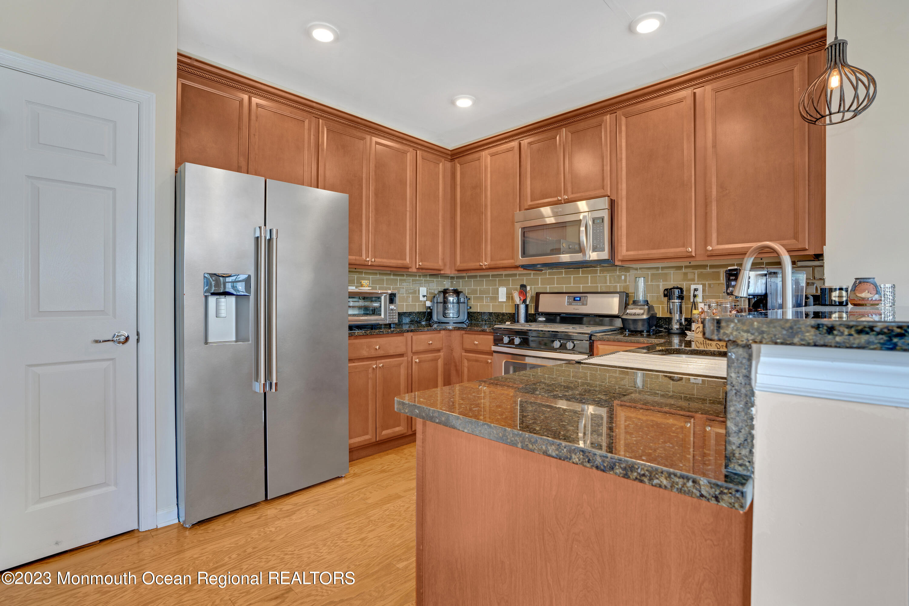 7 Iris Lane, Unit 504 Garfield, NJ 07026 - Photo 8 of 31 a kitchen with stainless steel appliances granite countertop a refrigerator a stove and a sink with wooden cabinets