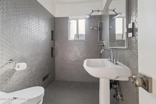 a bathroom with a sink a toilet and mirror