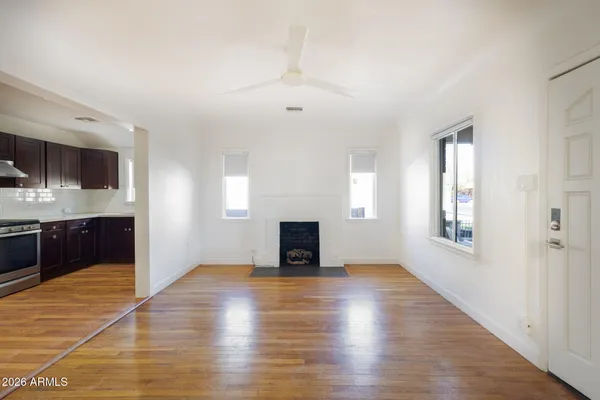 a view of a livingroom with wooden floor and a fireplace
