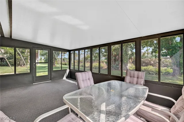 a living room with furniture and floor to ceiling windows