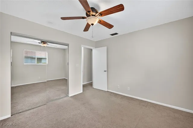 an empty room with chandelier fan