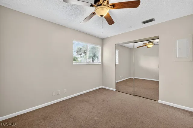 an empty room with fan and windows