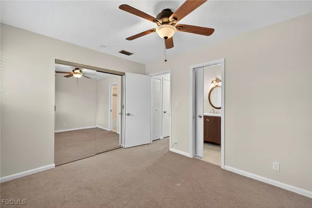 an empty room with a window and a ceiling fan