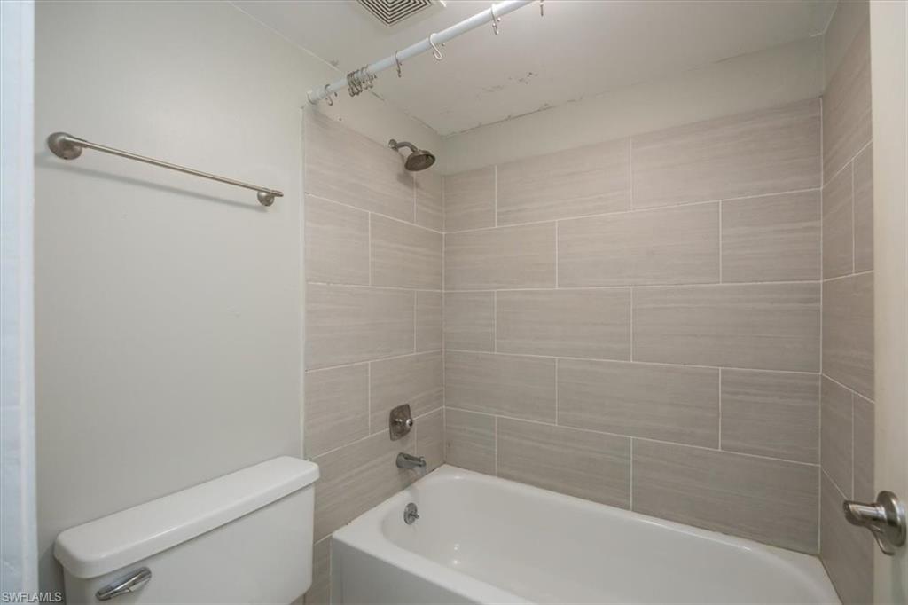 3635 Boca Ciega Drive, Unit 207 Naples, FL 34112 - Photo 15 of 24 a white bath tub sitting next to a white toilet and a shower
