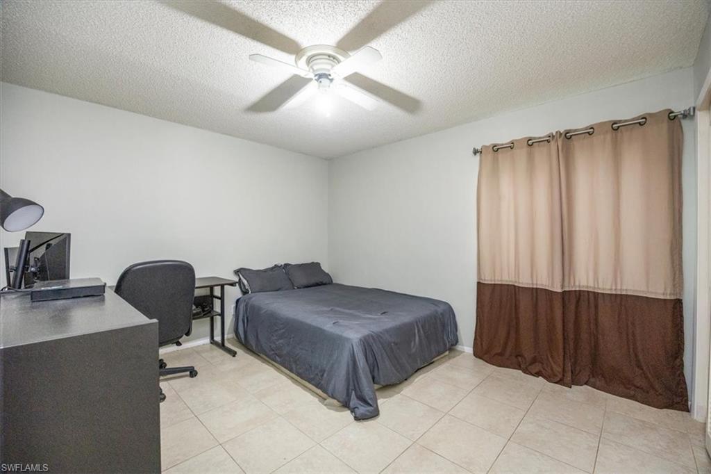 3635 Boca Ciega Drive, Unit 207 Naples, FL 34112 - Photo 10 of 24 a bedroom with a bed and a chair