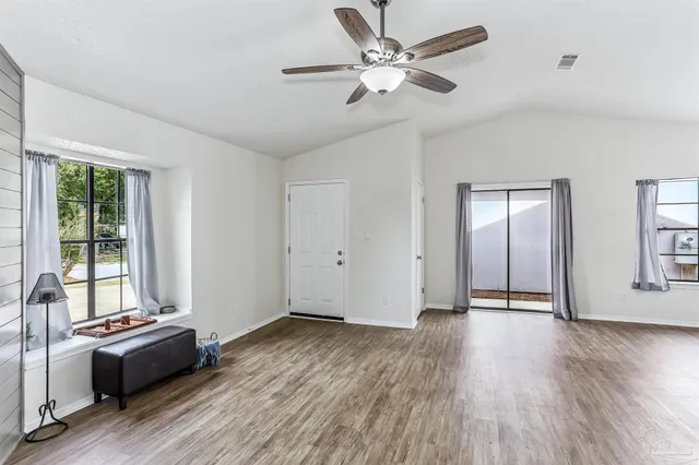 a view of a livingroom with wooden floor and a ceiling fan