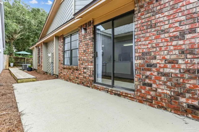 a view of a roof deck with table and chairs under an umbrella