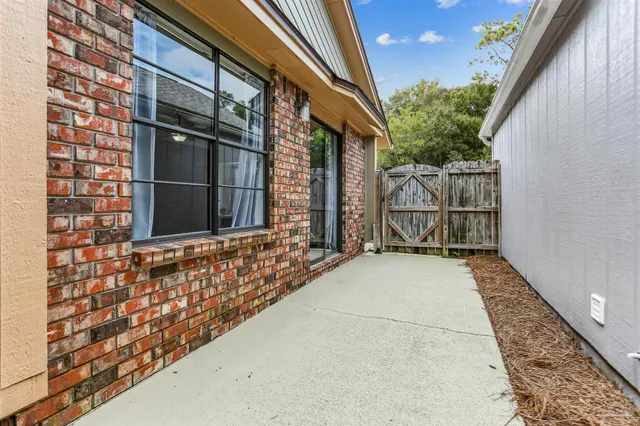 a patio with a table and chairs under an umbrella